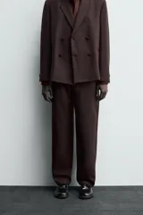Pantalón de traje straight fit color marrón oscuro, confeccionado en tejido con lana. Cuenta con bolsillos frontales, bolsillos traseros de vivo y cierre frontal con cremallera y gancho metálico oculto.
