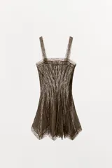 Vestido corto de escote recto y tirantes anchos, confeccionado en tejido combinado con aplicaciones de encaje a tono y detalle de godets en la falda. Cuenta con cierre lateral oculto.