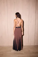 Vestido largo de seda color marrón con estampado de lunares blancos y detalles de encaje negro. Presenta un diseño entallado en el torso, escote en V profundo y espalda descubierta con tiras cruzadas.