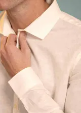 Camisa de manga larga en color salmón con estampado de pequeños motivos geométricos oscuros, cuello clásico y cierre frontal con botones.
