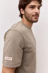 Remera blanca de algodón, de corte holgado y mangas cortas, con pequeño estampado azul en el pecho.