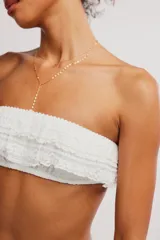 Top bandeau de tejido texturado marrón con escote recto y detalle de volados fruncidos.