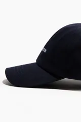 Gorra de sarga de algodón color azul marino, con diseño bordado frontal con la frase "Creative Director" en color blanco y visera curva.