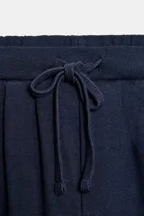 Pantalón balloon de algodón color crudo, con tiro medio, cintura elástica ajustable con cordón y bolsillos laterales.