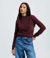 Blusa de manga larga confeccionada en tejido de chenille con textura aterciopelada y cuello alto. Presenta un diseño ajustado con puños y ruedo acanalados.