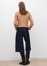 Chaqueta de tweed color tostado con cuello redondo, manga larga, cuatro bolsillos de parche con solapa en la parte delantera y cierre de botones con efecto joya. Presenta terminaciones deshilachadas y forro interior.