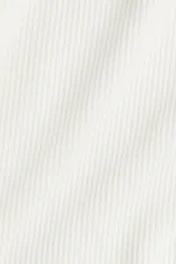 Remera polo de manga larga color blanco, confeccionada en tejido de punto acanalado. Presenta cuello clásico y tapeta frontal con botones dorados.