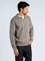 Sweater tipo polo de punto con diseño de trenzas, color azul marino, con cuello clásico y abertura frontal.