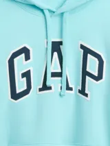 Canguro de abrigo Gap color turquesa, con capucha ajustable por cordón, bolsillo tipo canguro al frente y el clásico logo de la marca bordado en el pecho con letras negras y bordes blancos.