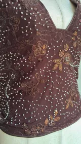 Top marrón con lentejuelas plateadas, escote halter y espalda descubierta.