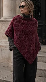 Poncho tejido de punto en color bordó, con diseño asimétrico y terminaciones acanaladas en los bordes.