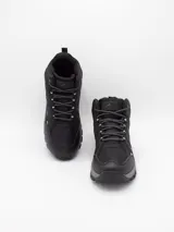 Bota de trekking color negro, con diseño de caña media, confeccionada en materiales sintéticos resistentes y malla transpirable. Cuenta con suela de goma dentada para mayor tracción y cordones reforzados.