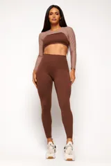 Calza deportiva marrón de tiro alto, confeccionada con tecnología de compresión y diseño ajustado.