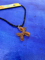 Collar corto de cuentas negras facetadas con dije de perro salchicha tipo globo en resina color ámbar con destellos brillantes.