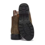 Bota tipo chelsea Blundstone modelo 585, confeccionada en cuero premium rústico color marrón. Presenta diseño de punta redonda, elásticos laterales a tono, tiradores en la parte superior y suela de TPU de alta durabilidad con entresuela acolchada.