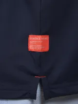 Chomba de piqué negra, de corte clásico, con cuello polo y tapeta de dos botones.