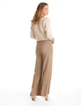Pantalón de tiro alto con corte wide leg, confeccionado en tejido elastizado. Presenta una costura vertical decorativa en el frente de cada pierna y un diseño de calce cómodo.