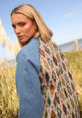 Campera de jean con mangas de denim azul y espalda con tejido estampado de motivos étnicos en tonos tierra, verde y azul.