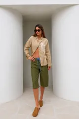 Bermuda de calce relajado y pierna amplia, color amarillo, con largo por debajo de la rodilla y cordón ajustable negro en la cintura.