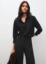 Pantalón de vestir negro de corte recto y tiro medio, con bolsillos laterales y trabillas para cinturón. Incluye un cinturón delgado a juego.