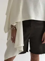 Ruana de tejido de punto trenzado en color crudo, con diseño abierto, corte holgado y mangas amplias tipo kimono.