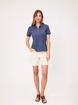Short de denim elastizado de tiro alto, color beige, con bolsillos delanteros y traseros, y cierre frontal con botón y cremallera.