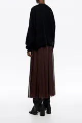 Falda midi de corte fluido con diseño acampanado y vuelo. Presenta una textura ligera y semitransparente con forro interior a tono.