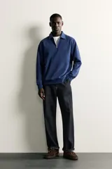 Sudadera polo de corte regular, confeccionada en tejido técnico interlock de algodón con elasticidad. Presenta cuello solapa, cierre frontal de cremallera y manga larga con puños acabados en rib.