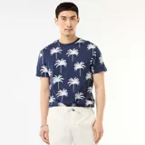 Remera azul marino de manga corta con estampado integral de palmeras blancas.