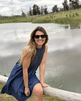 Vestido corto sin mangas de denim azul, con diseño holgado y detalle de nido de abeja (smock) hecho a mano con costuras en hilo marrón en la parte superior.