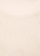 Jersey de punto calado en color crema, con cuello redondo, manga corta y terminaciones de canalé en cuello, mangas y ruedo.