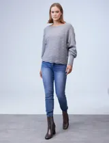 Buzo verde militar de tejido acanalado con detalles calados en el frente. Tiene cuello redondo y mangas largas amplias con puños elastizados.