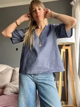 Blusa celeste de denim con escote en V y mangas cortas amplias.