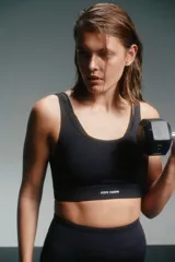 Top deportivo negro con breteles finos cruzados en la espalda y banda inferior con el logo de la marca Caro Cuore.