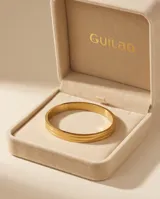 Pulsera tipo esclava rígida de acero con baño de oro, con diseño de líneas paralelas y acabado pulido.