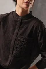 Camisa de lino color crudo con bolsillo frontal cuadrado destacado con bordado richelieu y diseño geométrico floral.