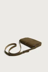 Bolso tipo bandolera de piel con acabado serraje, compartimento principal con cierre de solapa e imán, bolsillo posterior y asa de hombro ajustable.
