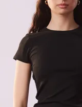 Remera negra de tejido acanalado, marca Cyrus, con escote a la base y manga corta.