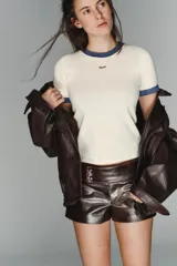 Shorts de tiro bajo confeccionados en material con acabado efecto cuero brillante. Presentan cintura ancha con detalle de botones forrados en el frente y cierre frontal con cremallera.