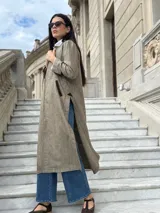 Tapado largo de paño liviano con diseño de cuadros en tonos marrones. Presenta solapas clásicas, bolsillos laterales con detalles en cuero y tajos profundos en los costados.