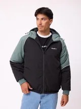 Campera Rusty con capucha, diseño bicolor en negro y verde militar. Presenta cierre frontal, puños elásticos y logo de la marca bordado en el pecho.