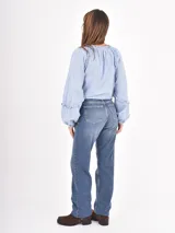 Jean de corte recto y tiro medio, en color azul clásico con efecto de lavado desgastado. Cuenta con cierre frontal y bolsillos laterales.