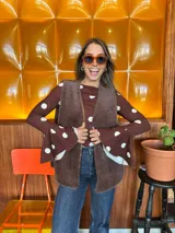 Blusa de manga larga ajustada al cuerpo, color marrón con estampado de lunares blancos. Presenta un cuello redondo con caída suave y mangas acampanadas con volados en los puños.