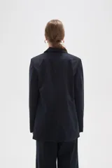 Blazer de corte holgado con diseño de rayas verticales, cuello solapa y cierre frontal con un botón. Cuenta con bolsillos laterales con solapa.