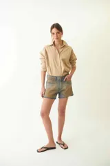 Short de jean con tiro bajo, efecto desgastado y estampado de serpiente. Tiene cuatro bolsillos, pasacintos, cremallera y botón metálico.