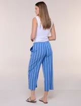 Pantalón de algodón rústico color verde, de tiro medio-alto con pretina elastizada y bolsillos laterales. Presenta corte holgado, diseño cropped de pierna ancha y aberturas laterales en los tobillos con detalles de botones.