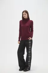 Polera de lyocell color negro, con cuello alto y ajuste al cuerpo, de manga larga.