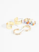 Set de tres pares de caravanas doradas con forma de aro. Un par es liso, otro tiene strass blancos y el tercero tiene strass de colores.