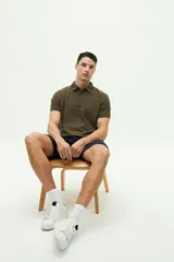 Remera polo gris con cuello y mangas con borde blanco, logo bordado en el pecho y corte regular. Confeccionada en algodón y spandex.