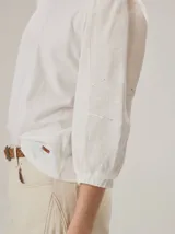 Blusa de diseño combinado con cuerpo delantero y espalda de algodón negro, y mangas abullonadas tres cuartos de lino en color beige con puños elásticos negros.